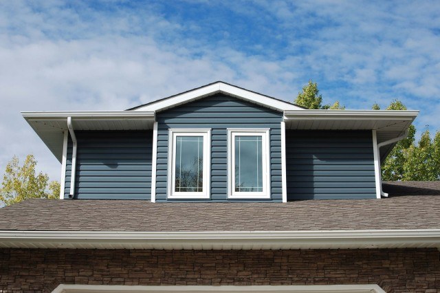 exterior shot of the second storey windows of a house with blue siding